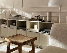 a living room filled with lots of furniture and bookshelves next to a window