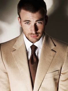 a man in a tan suit and tie