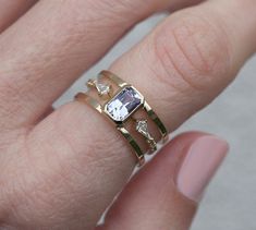 a woman's hand with a ring on it and a diamond in the middle