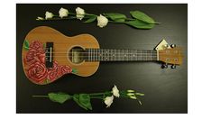 a ukulele decorated with flowers and roses