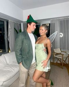 a man and woman dressed up as tinkerbells in a living room together