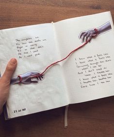 a hand holding a string attached to an open book