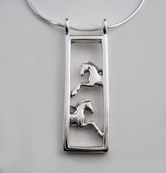 Framed Pair of Horses Necklace in Sterling Silver. Clean lines frame the pair of horses, galloping from each side of the frame. The Framed Pair of Horses Pendant measures 7/16" wide by 1-3/8" long and comes on a 16" Sterling Silver chain. Matching earrings are available to order alone or as a set. Add a delightfully imaginative matching pair of earrings. Each Framed Pair of Horses Earring measures 5/8" long by 5/16" wide and hangs off a sterling silver ear wire. Ready to Ship. Gift Boxed Horses Galloping, Minimalist Necklace Silver, Horseshoe Jewelry, Horse Bracelet, Horse Earrings, Equestrian Jewelry, Horse Necklace, Silver Horse, Horse Jewelry