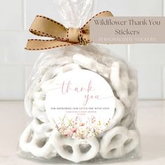 a bag filled with white pretzels sitting on top of a counter next to a sign that says, thank you