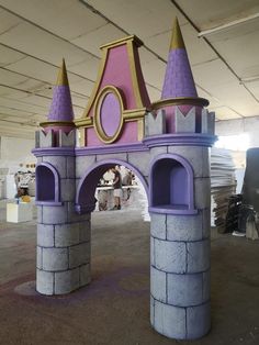 a castle made out of concrete with purple turrets