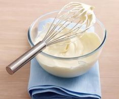 a whisk in a glass bowl on top of a blue napkin