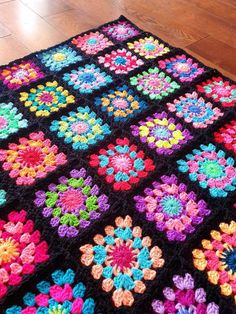 a multicolored crocheted granny afghan on the floor