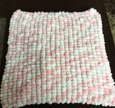 a pink and white rug sitting on top of a wooden table