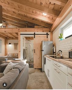 a kitchen and living room are shown in this house with wood paneling on the ceiling