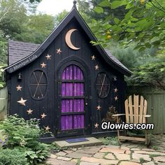 a purple house with stars and moon decorations on the roof, sitting next to a wooden chair