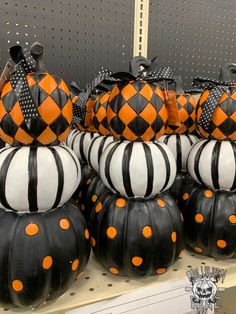 black and white pumpkins with orange polka dots are on display in a store shelf