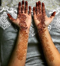 two hands with henna tattoos on them