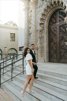 a man and woman walking down some stairs