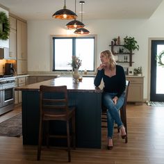 a woman is sitting at the kitchen island