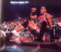 a basketball player sitting on the floor in front of an audience