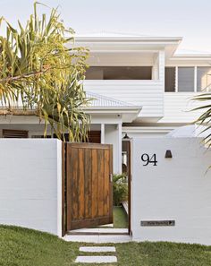 a white house with a wooden door and number 94 on the front entrance to it