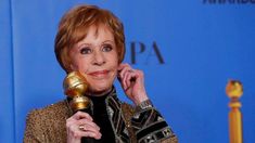 an older woman holding a golden microphone in front of her face