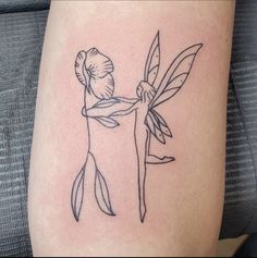 a woman with a tattoo on her arm holding onto a stick and ballerina's tail