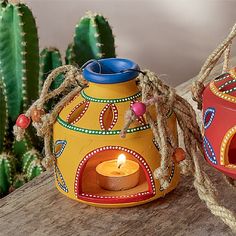 two brightly colored pots with candles in them