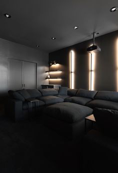 a living room filled with black furniture and lots of lights on the wall above it