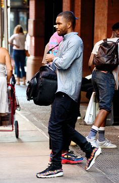 a man walking down the street with a child on his back and other people behind him