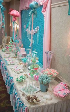 a long table covered in lots of desserts and candies on top of it