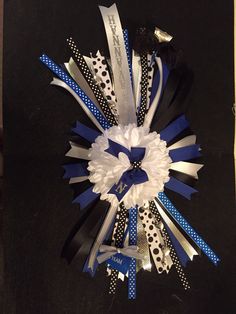 a bunch of blue and white ribbons on a black surface with polka dot ribbon around it