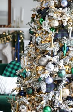 a decorated christmas tree in a living room with green and white ornaments on the top