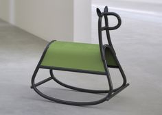 a green rocking chair sitting on top of a white floor