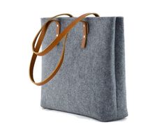 This felt bag with leather handles and zipper closure was created in my small studio. It was made out of very durable technical felt, 4mm thick and thick natural leather. It is a very minimalist gray felt handbag. Great gift idea for her. Measurements: width 41 cm/ 16 inch height 31 cm/ 12.2 inch depth 12 cm/ 5 inch The bag was made taking care of each small detail. - top zipper closure, - one zippered pocked inside the bag, - 1 pocket for a mobile phone inside. Other colors available. Please ch Macbook Pouch, Felt Handbag, Minimalist Handbag, Felt Tote Bag, Felt Case, Felt Tote, Felted Handbags, Grey Shoulder Bag, Leather Rivets