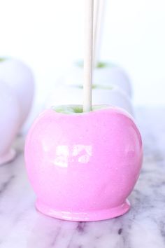 an apple shaped candy bar sitting on top of a marble counter next to two white vases