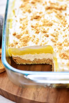 a casserole dish filled with food on top of a wooden cutting board next to crackers