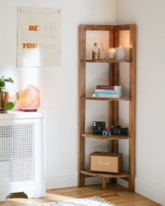 a white room with a book shelf and rug on the floor next to a wall