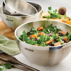 two stainless steel bowls with salad in them