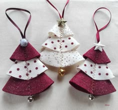 three christmas tree ornaments hanging from red ribbon