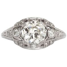 an antique style diamond ring with filigrees on the sides and round brilliant cut diamonds