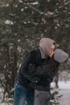 a man standing in the snow talking on his cell phone