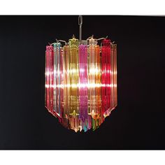 a multicolored chandelier hanging from a ceiling fixture in a dark room