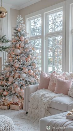 a living room with a white christmas tree in the corner and pink ornaments hanging from the ceiling