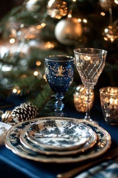 a christmas table setting with blue and white plates