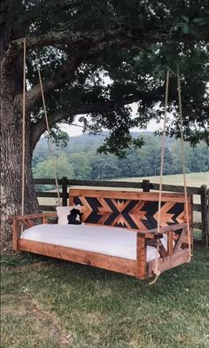 a wooden swing bed hanging from a tree