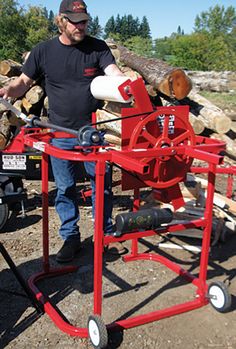 a man standing next to a red fire hydrant on top of a pile of logs