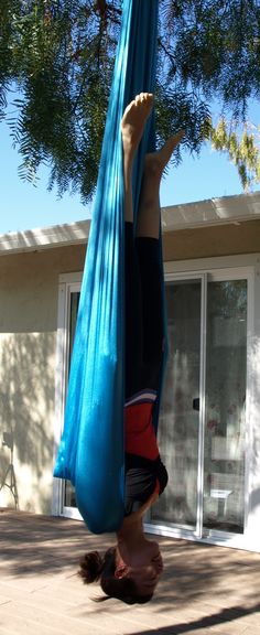 a woman hanging upside down in a hammock