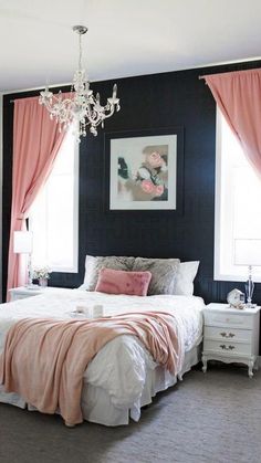 a bedroom with black walls, pink curtains and a white bed in front of a chandelier