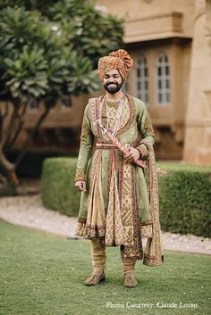 a man in a turban standing on the grass