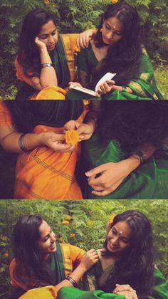 two women sitting in the grass and one is holding an orange flower while another woman looks at her cell phone