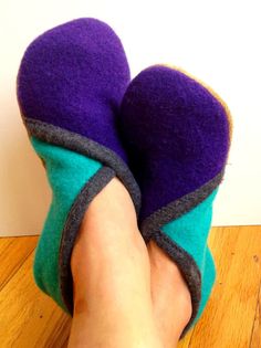 someone is wearing purple and green slippers on their feet