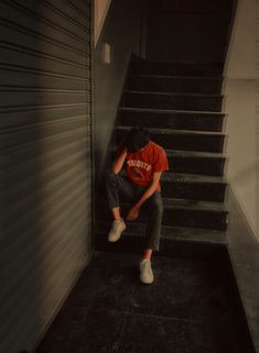 a person sitting on some stairs with their head down