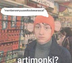 a man wearing a red hat with the words artmonki in front of him