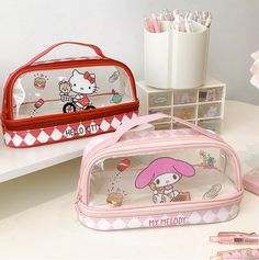 two hello kitty pencil cases sitting on top of a desk